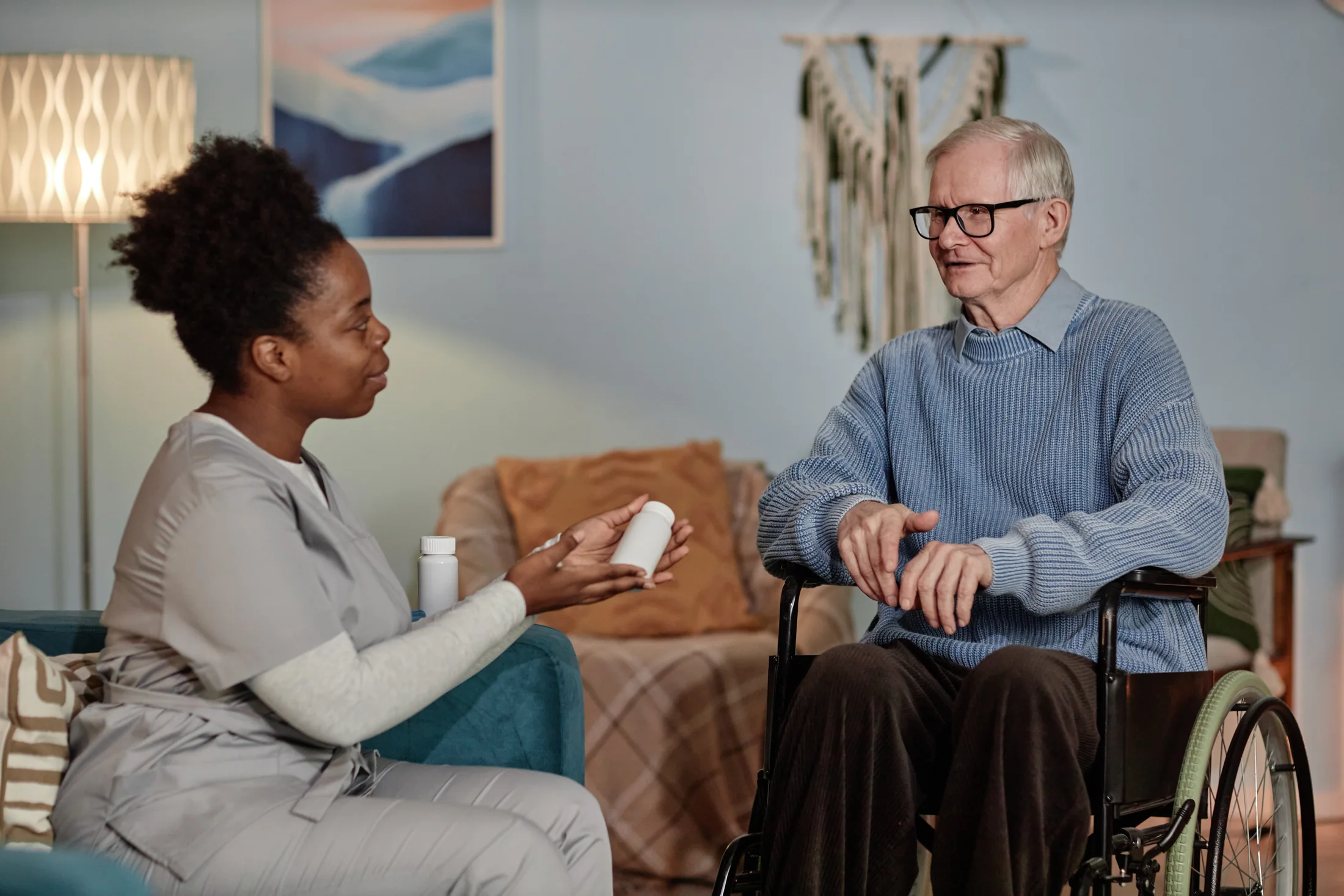 Caregiver reviewing a medication container with an older man