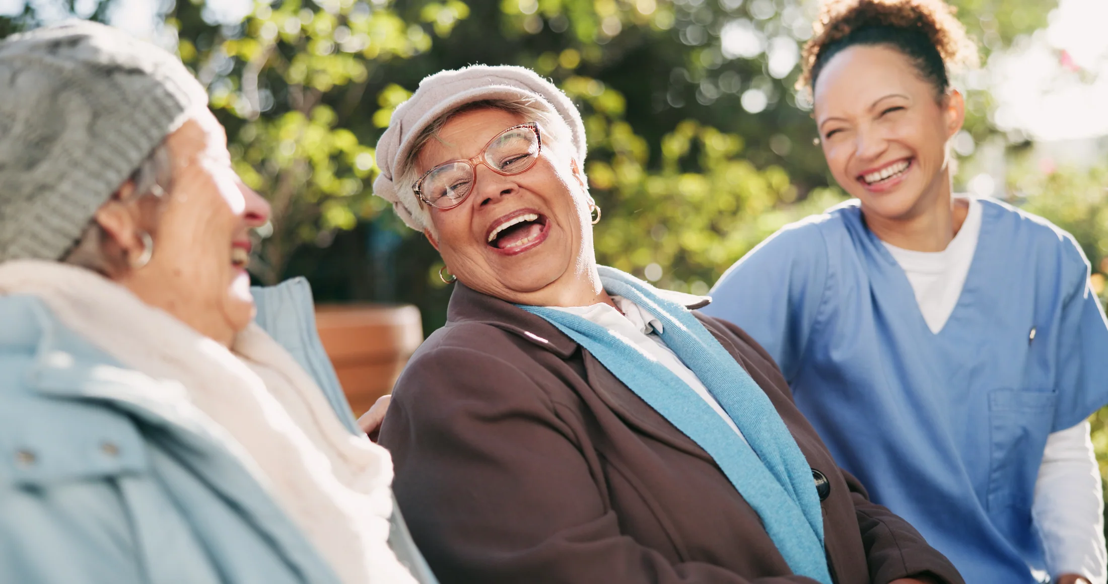 Caregiver spending time outdoors with an older adult who uses a wheelchair